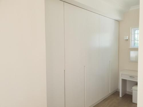 a room with white walls and a white toilet at Villa Karibu in Tokai