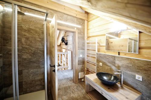 - une salle de bains avec lavabo dans une maison en bois dans l'établissement Summit Lodges, à Pfunds