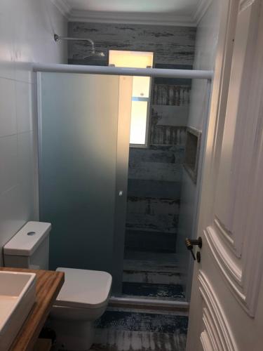 baño con aseo y lavabo y ventana en Flat Geribá com linda vista, 500 metros da praia, en Búzios