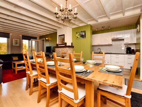 una cucina e una sala da pranzo con tavolo e sedie in legno di Modern Holiday Home with Private Garden a Tenneville