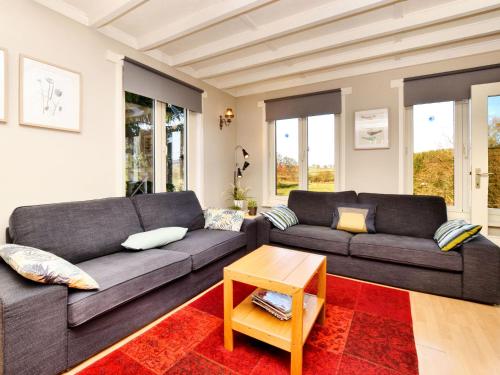 un soggiorno con divano e tavolo di Modern Holiday Home with Private Garden a Tenneville