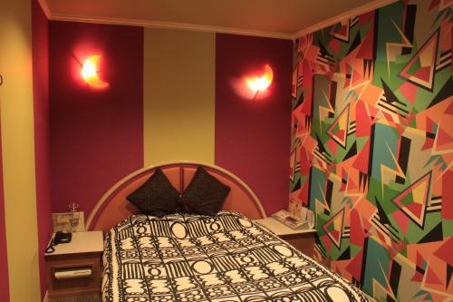 a bedroom with a bed and a colorful wall at Hotel Miami (Adult Only) in Metabaru