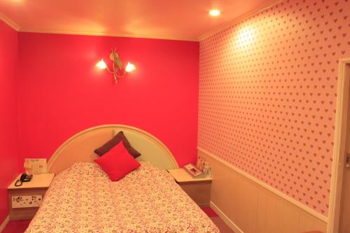 a bedroom with a bed with a red wall at Hotel Miami (Adult Only) in Metabaru