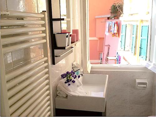 een badkamer met een wastafel en een raam bij Ancient Porticciolo - Nervi Genova in Genua