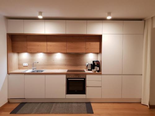 a kitchen with white cabinets and a sink at Haus Hager Inge in Ellmau