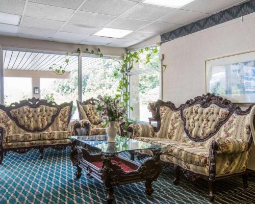 a living room with couches and a glass table at Rodeway Inn in Gadsden
