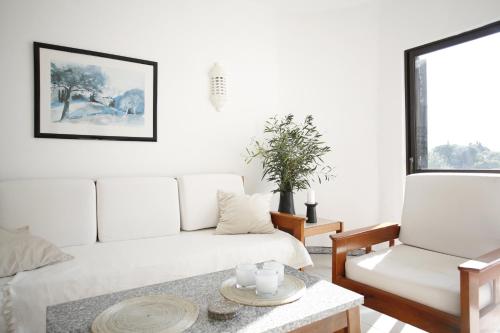 een woonkamer met een witte bank en een tafel bij CASA CARVOEIRO in Poço Partido