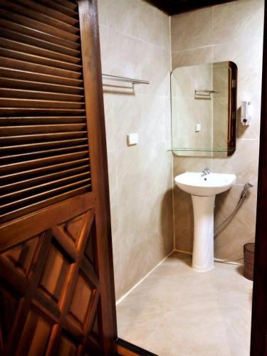 a bathroom with a sink and a toilet and a mirror at Cozy Garden Resort in Ao Nang Beach