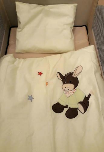a bed with a stuffed animal on it at Ferienwohnung Hornig Zwei Terrassen, Parkplatz, separater Eingang in Sulzfeld am Main