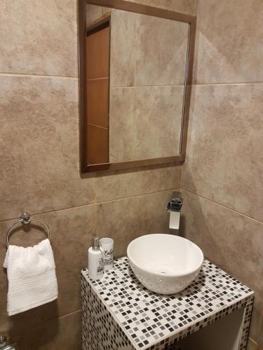 W łazience znajduje się umywalka i lustro. w obiekcie Departamento Centeno. Centrico. w mieście Santa Rosa
