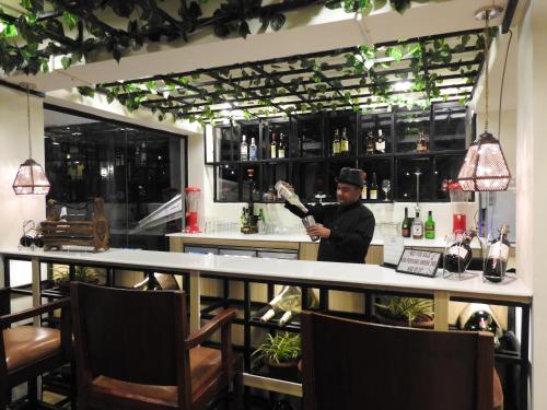 a man standing behind a bar with a guitar at Polo Cherrapunjee Resort in Cherrapunji