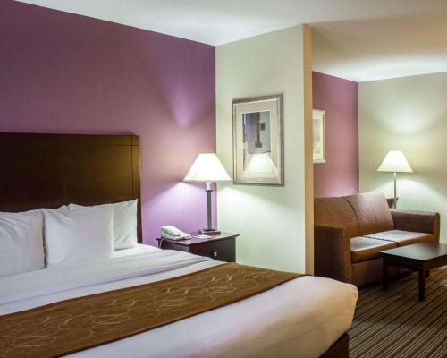 een hotelkamer met een bed en een stoel bij Comfort Suites in Sanford