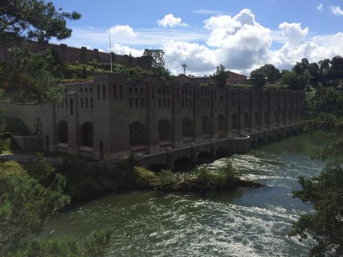 a bridge over a river next to a building at Hotell Bele in Trollhättan
