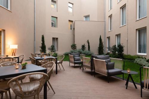 a patio with tables and chairs in a building at Eurostars Porto Centro in Porto