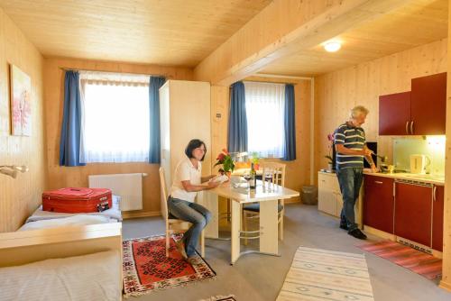 Ein Mann, der an einem Tisch in einem kleinen Raum sitzt. in der Unterkunft Gästehaus Aquilin in Sankt Pölten