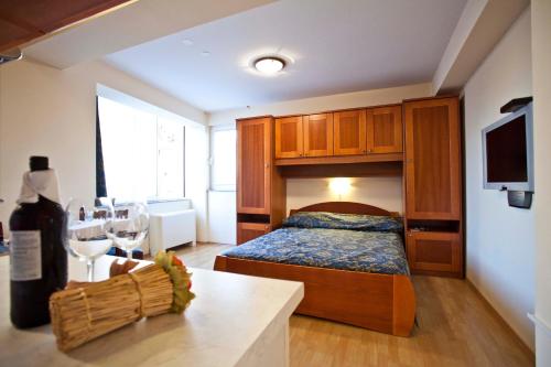 a bedroom with a bed and a bottle of wine at Studio Apartmani Bijeli Delfin in Biograd na Moru
