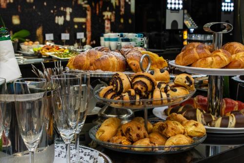 a buffet with several plates of bread and pastries at Carat Boutique Hotel in Budapest