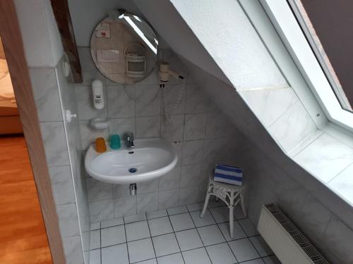 a bathroom with a sink and a mirror at Pension Apostel in Wismar