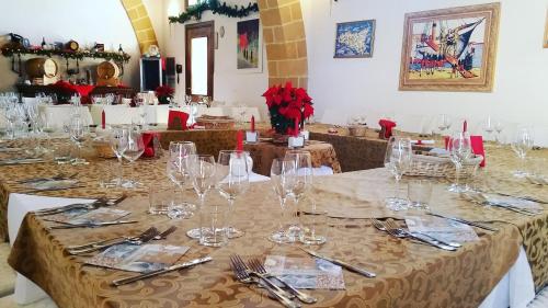 a dining room with a table with glasses and silverware at Baglio Cudia Resort in Marsala