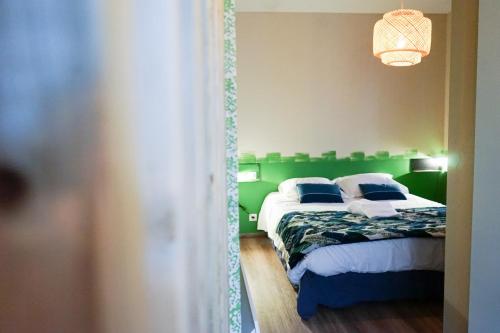 ブリーヴ・ラ・ガイヤルドにあるDUMYRAT #2 - Véritable pépite - 1 chambreのベッドルーム1室(ベッド2台、緑のヘッドボード付)