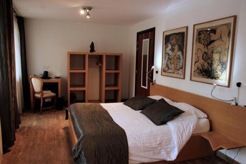 - une chambre avec un grand lit et un bureau dans l'établissement ART Hôtel, à Kaysersberg