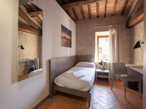 1 dormitorio con cama, escritorio y ventana en Ostello del Castello di Santa Severa, en Santa Severa