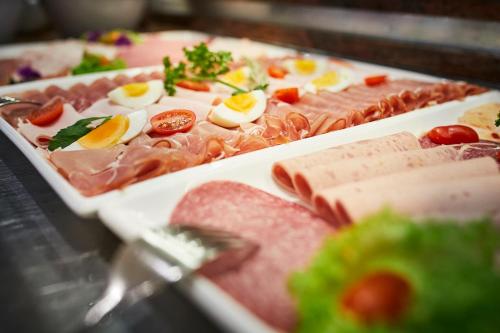 a plate of food with meats and eggs on it at Göbels Landhotel in Willingen