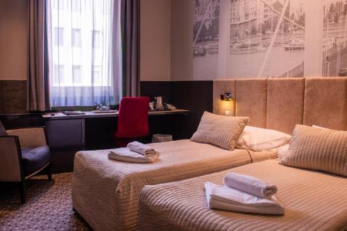 a hotel room with two beds with towels on them at Carat Boutique Hotel in Budapest