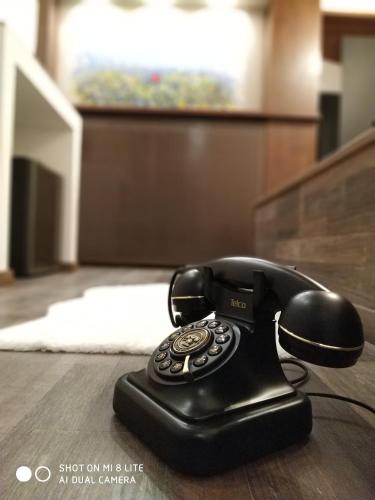 a black phone sitting on top of a wooden floor at Oasi in Kato Loutraki