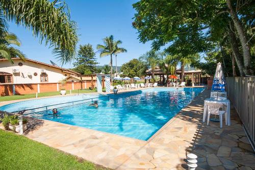 a large swimming pool with people in the water at Hotel Castelo in Gravatal