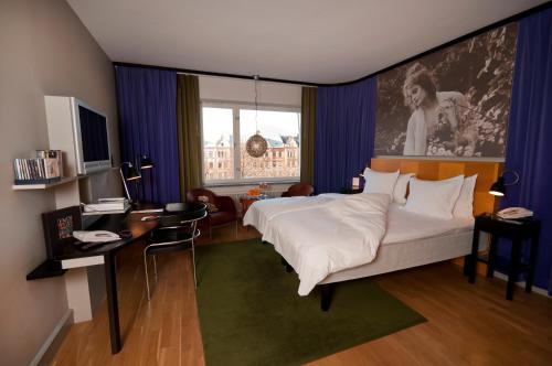 a bedroom with a bed and a desk and a tv at Hotel Rival in Stockholm