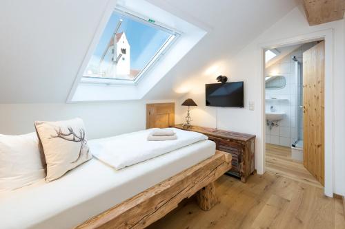 a bedroom with a bed with a skylight at Landhaus Kössel in Füssen