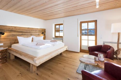 a bedroom with a large bed and a chair at Landhaus Kössel in Füssen