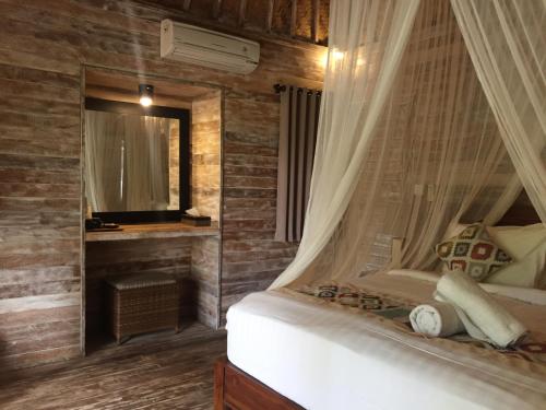 een slaapkamer met een bed met een klamboe bij Green Garden Lembongan Yoga Spa and Holistic Healing Center in Nusa Lembongan