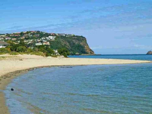 a beach with a town on top of a hill at The Knysna Belle Guest House in Knysna