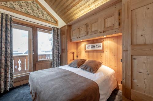 a bedroom with a bed in a room with a window at Hotel Eterlou in Méribel