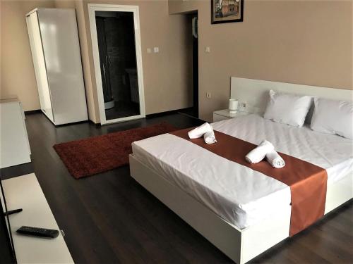 a bedroom with a bed with two towels on it at Hotel Oppium Restaurant & Garden in Ruse