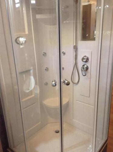 a bathroom with a shower with a glass door at Dogis Retreat in Ayia Evfimia