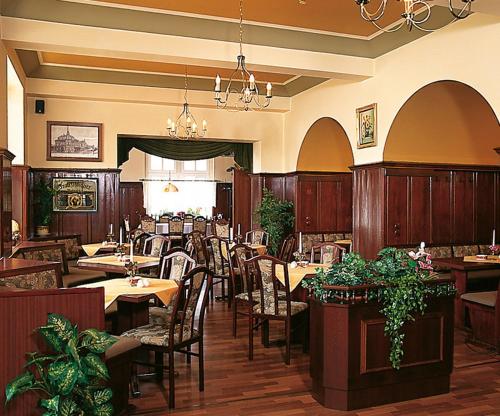 una sala da pranzo con tavoli e sedie in un ristorante di Hotel - Restaurant Kurhaus Klotzsche a Dresda