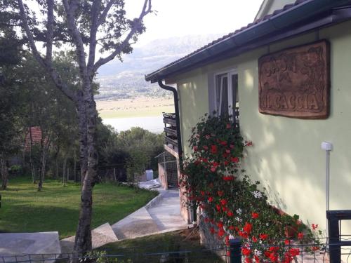 a house with flowers on the side of it at Green House Source Vrilo in Tomislavgrad