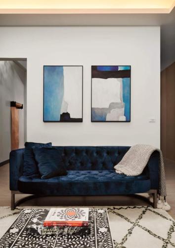 a blue couch in a living room with four paintings at Chloechen Home in Taitung City