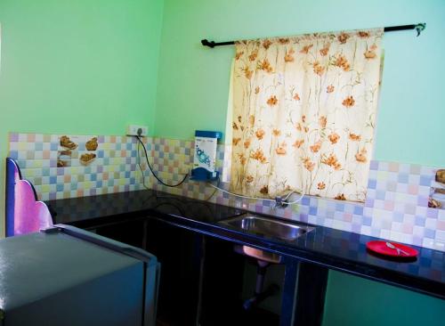 a bathroom with a sink and a shower curtain at Dio's Guest House in Utorda