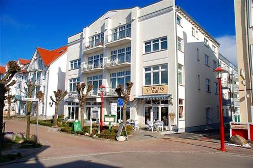 ビンツにあるHaus Jahreszeiten Appartement Meeresrauscher by Unsere Urlaubszeitの通角の白い大きな建物