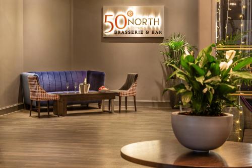 a lobby with a blue couch and chairs and a table at Copthorne Hotel Plymouth in Plymouth