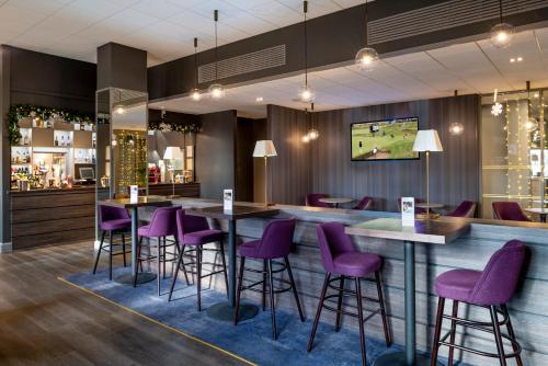 a bar in a restaurant with purple stools at Copthorne Hotel Plymouth in Plymouth