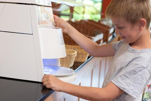 a young boy holding a lamp in a refrigerator at Familienhotel Citylight in Berlin