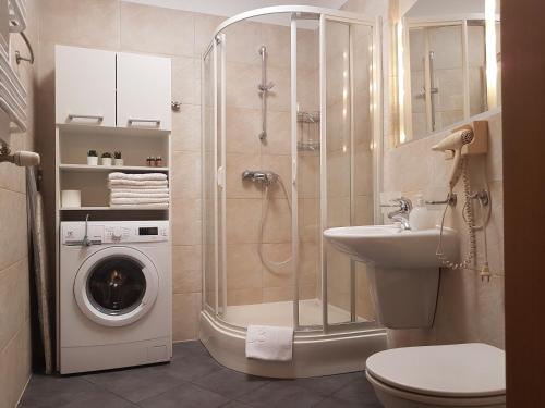 a bathroom with a shower and a washing machine at Apartament 316 w Domu Zdrojowym in Jastarnia
