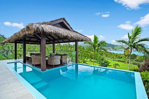 a villa with a swimming pool and a gazebo at Mandalay Luxury Retreat in Airlie Beach