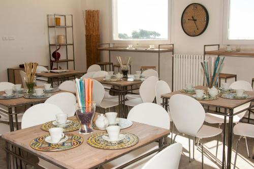 a room with tables and white chairs and a clock at Agriturismo Cozzo di Papaleo in Ragusa