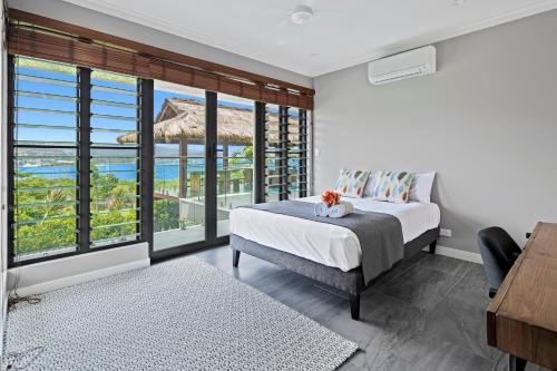 a bedroom with a bed and a view of the ocean at Mandalay Luxury Retreat in Airlie Beach